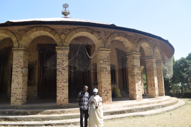 A round stone monastery church on Lake Tana, ringed by an arched colonnade under a corrugated roof