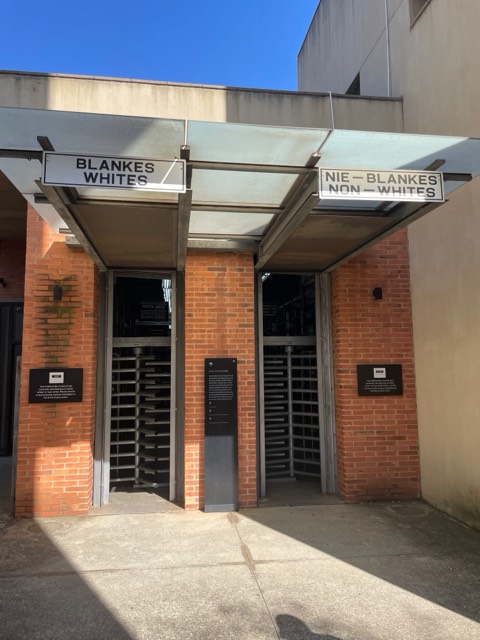 The segregated entrance turnstiles at the Apartheid Museum, signed BLANKES / WHITES and NIE-BLANKES / NON-WHITES