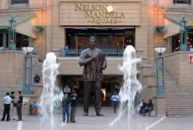 The bronze Nelson Mandela statue between fountains at Nelson Mandela Square in Johannesburg